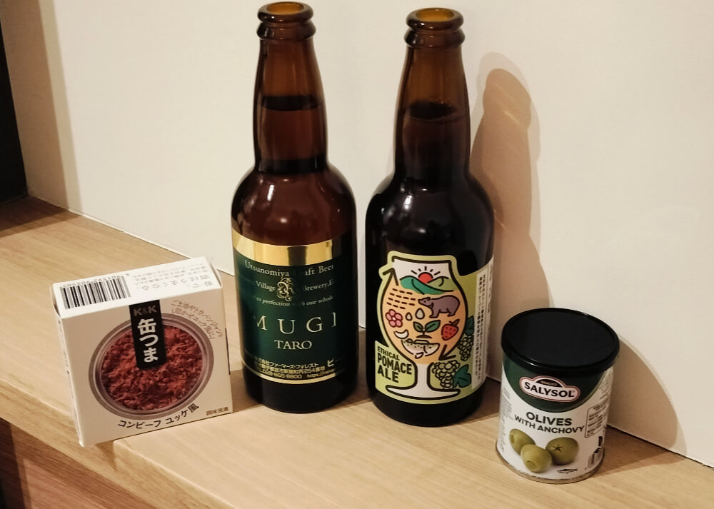 フロントで購入してきた缶つま「コンビーフゆっけ風」とオリーブ、瓶ビール
