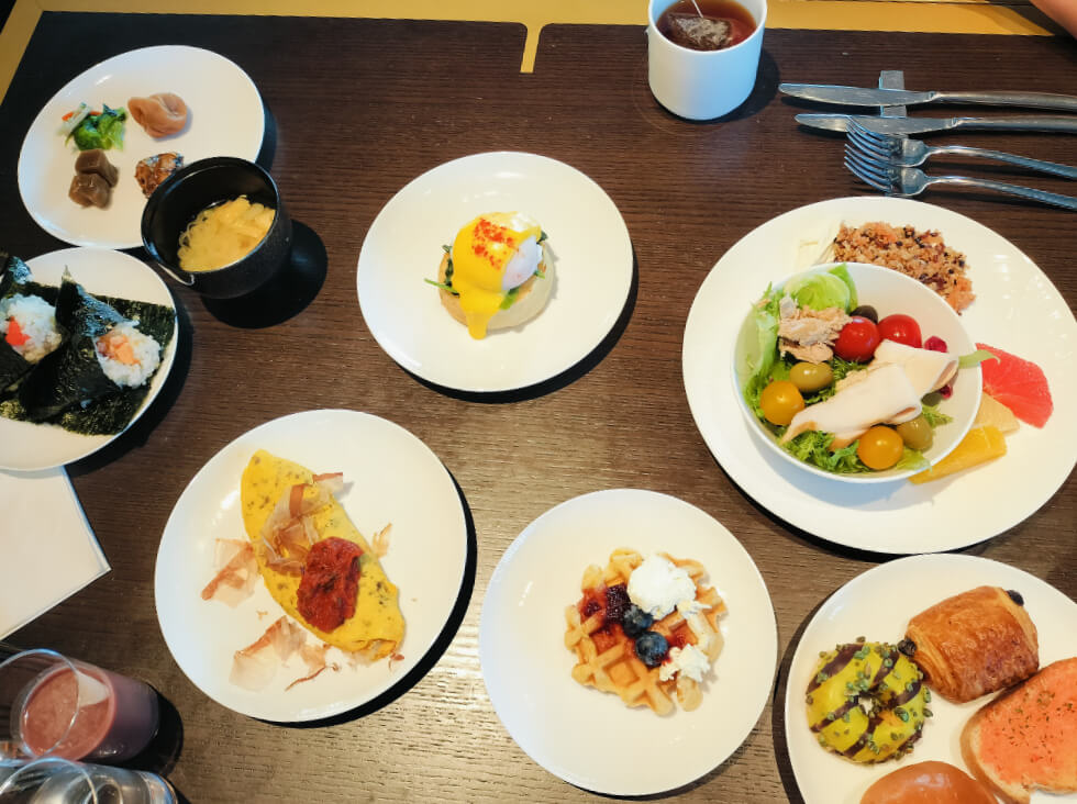 サラダやパン、エッグベネディクト、オムレツ、味噌汁、おにぎりなど。