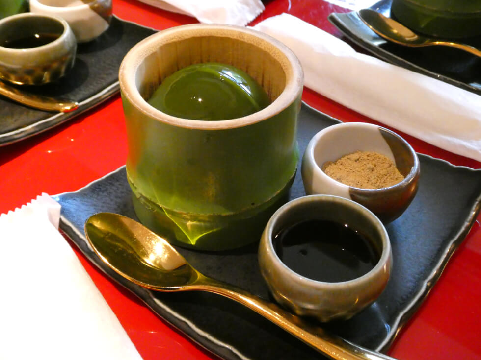 竹の容器に入った球型の抹茶プリン。きなこと黒蜜を添えて。